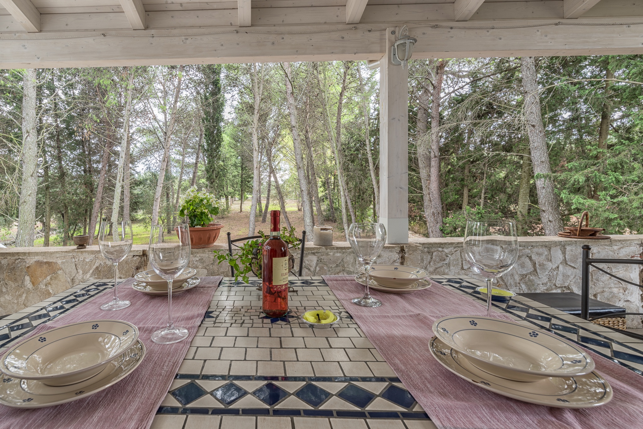 tavolo apparecchiato sotto portico con vista giardino